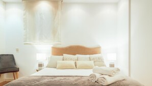 A hotel room with a bed, a chair, and a nightstand with a lamp. - Old Town Center: Origins and Tradition. (Bilbao)