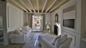 A room with a bed, two sofas, a fireplace, and a TV. - White Home in Florence by Mmega (Florence)