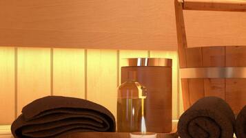 A wooden bath tub with a towel and a bottle of lotion.