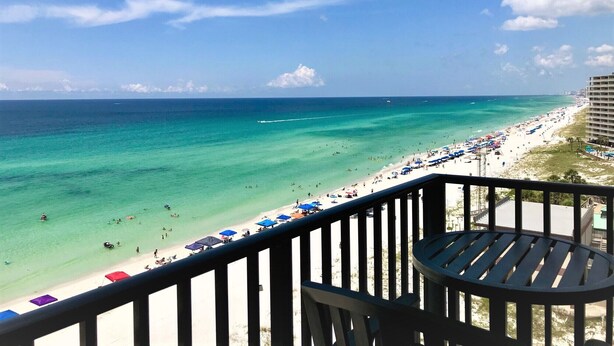 A balcony with a view of a beach and ocean.