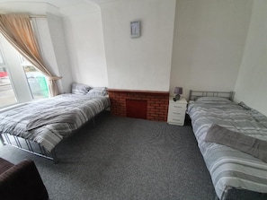 Tabla de planchar con plancha, camas supletorias, ropa de cama