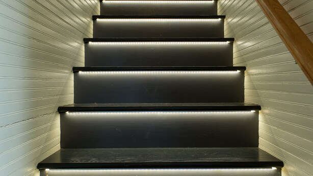 A staircase with illuminated steps and a wooden handrail. - Ramsay Estate Carriage House – Luxury Retreat with Mountain Views (Greenwood)