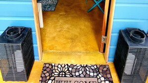 A doorway leading into a room with a kitchen area, a dining table, and a blue chair.