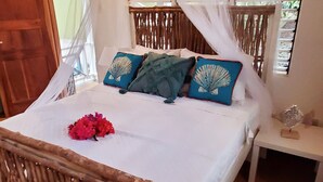 A bed with a canopy, a wooden headboard, and a patterned rug.