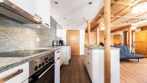Een moderne keuken met granieten aanrechtbladen, roestvrijstalen apparatuur en houten accenten.