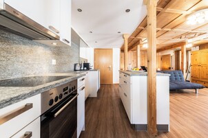 Una cocina moderna con encimeras de granito, electrodomésticos de acero inoxidable y detalles de madera.