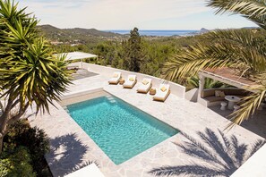 A swimming pool with sun loungers and a view of the sea. - Boutique Hotel Jardines de Palerm (Sant Josep de sa Talaia)