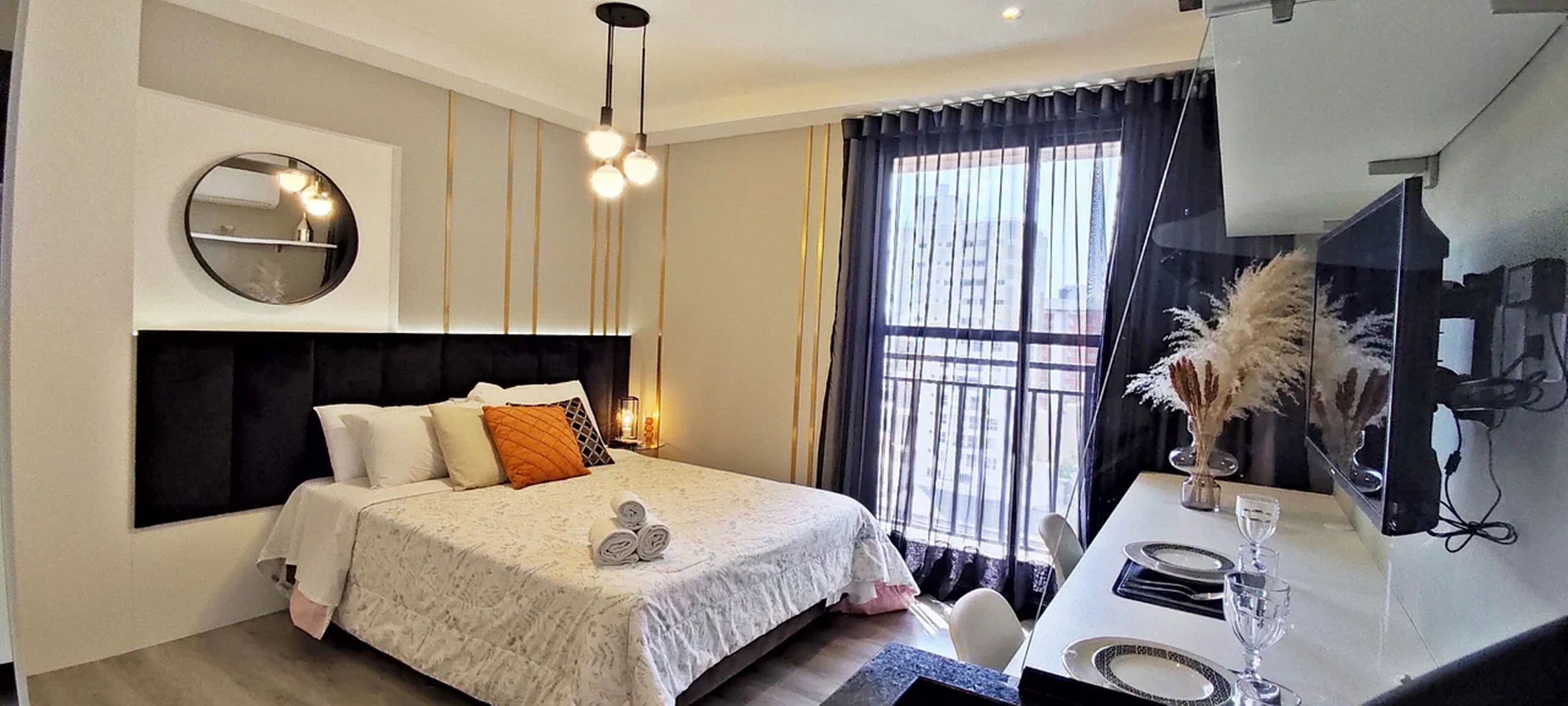 A modern bedroom with a bed, bedside table, and a large window with curtains.
