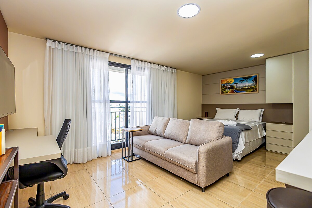 Une chambre d’hôtel avec un canapé, un lit, un bureau et une chaise.