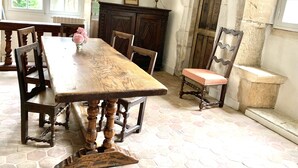 Una sala da pranzo con un tavolo in legno, sedie e un vaso di fiori.