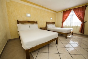 A hotel room with two wooden beds, a tiled floor, and a window with curtains. - OYO Hotel La Glorieta, Huichapan (Huichapan)
