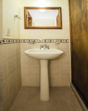 A bathroom with a pedestal sink, a mirror above it, and a tiled floor. - OYO Hotel La Glorieta, Huichapan (Huichapan)
