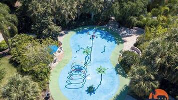 Relax by the serene pool surrounded by lush greenery and palm trees.