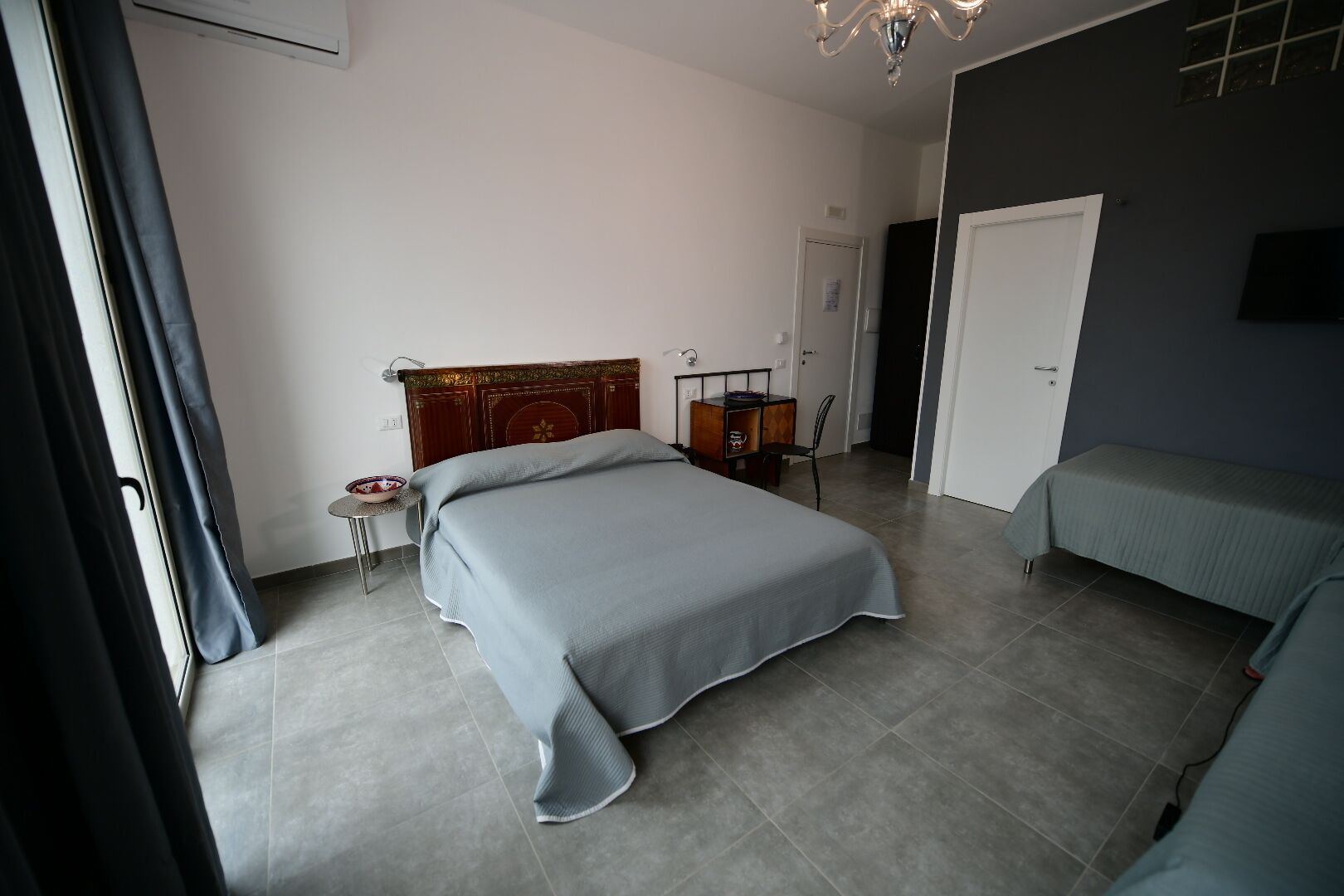 Une chambre à coucher comprenant un lit, une table de chevet, une chaise, un bureau et une armoire.