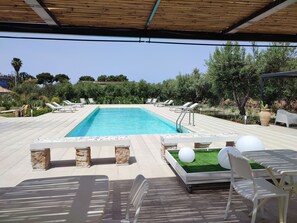A swimming pool with lounge chairs and a covered seating area. - Inkantu B&B (Terrasini)