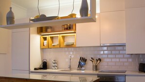 Eine moderne Küche mit Holzschränken, einem eingebauten Backofen und einer Glasinsel-Arbeitsfläche.