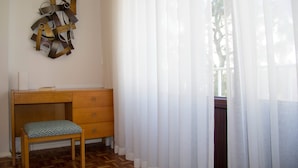 Ein Zimmer mit einem Holztisch, einer Bank und einem an der Wand befestigten abstrakten Kunstwerk.