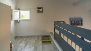Een trap met een houten vloer, een blauwe leuning en een klein tapijt.
