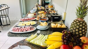 Un buffet de petit-déjeuner proposant une variété de fruits, de fromages et de charcuteries.