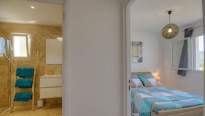 A bedroom with a bed, a bedside table, and a window. - T2 ground floor villa Magnificent sea view (Villanova)
