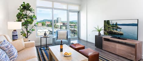 A modern living room with a sofa, coffee table, and TV stand.