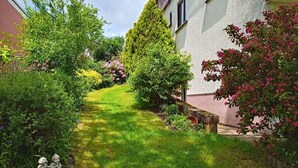 A well-maintained garden with a variety of plants and shrubs, a stone pathway, and a small bridge. - Ferienwohnung Schöne Aussicht (Weilrod)
