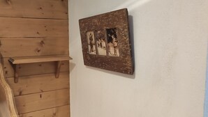 Un letto di legno con testata, una piccola mensola in legno e un quadro appeso al muro.