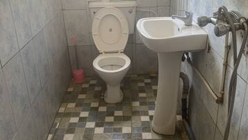 A bathroom with a toilet, sink, and shower.