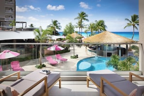 A balcony with lounge chairs and a pool view.