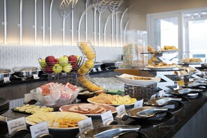 A buffet with various food items and utensils.