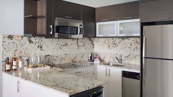 Una cocina moderna con encimeras de granito, electrodomésticos de acero inoxidable y lavavajillas.
