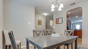 A dining room with a rectangular table, six chairs, and a chandelier. - Corporate, Lackland, Sea World, Alamo, Fiesta, Riverwalk BMT graduation (San Antonio)