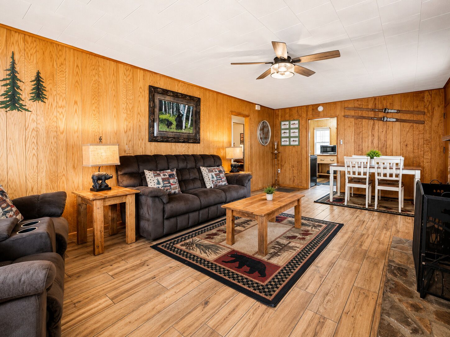 A cozy living room with a sofa, coffee table, and a ceiling fan.