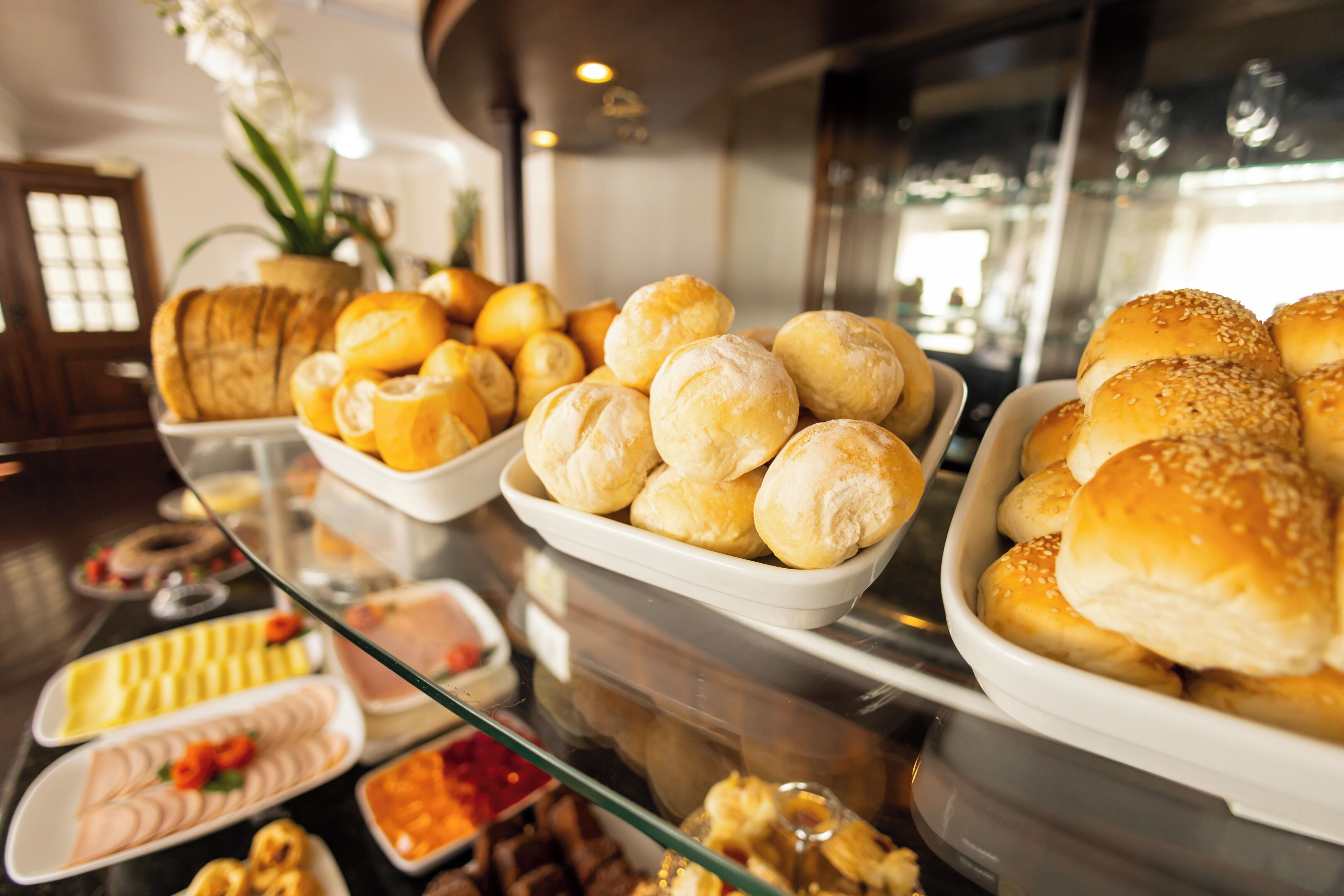 Un bufé con diversas opciones de panadería y postres, incluyendo panes, bollos y pastelería.