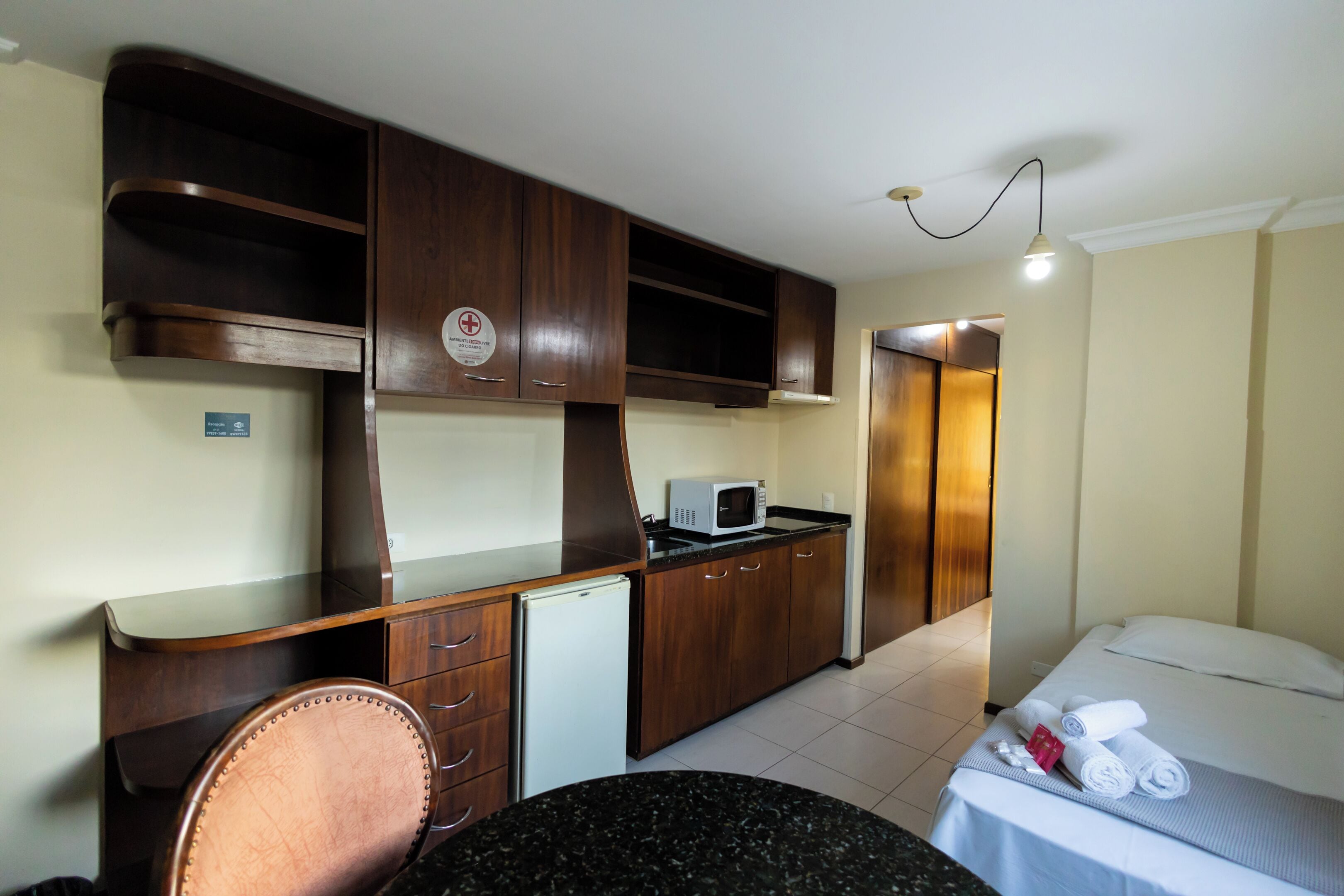 Habitació d'hotel amb cuina sencera, un llit, escriptori i cadira.