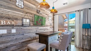 A bar area with wooden wall decor, a green sports-themed poster, and a sign indicating a bar. - Beautiful New Townhome nestled in the Pines! (Flagstaff)