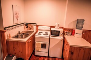 Enjoy cooking in this fully equipped kitchen with a stainless steel sink, stove, and microwave, plus ample storage and a convenient water dispenser.