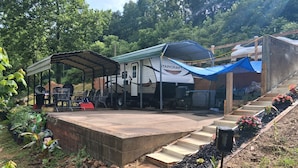 A covered outdoor area with a StarCraft RV, outdoor seating, and a small garden.