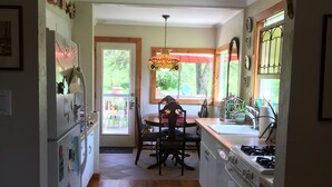 Una cocina con comedor, suelo de madera y un tapete azul con motivos florales.