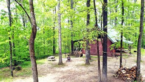Una cabaña rústica rodeada de altos árboles en un bosque.
