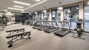 A modern gym with treadmills, elliptical machines, and benches. - Courtyard by Marriott Ames (Ames)