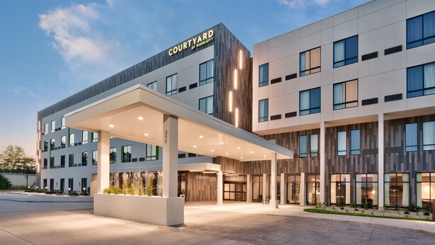 A modern hotel with a covered entrance, multiple floors, and a prominent 'Courtyard by Marriott' sign. - Courtyard by Marriott Ames (Ames)