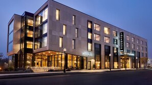 A modern hotel with a glass facade, outdoor seating area, and a sign indicating 'Front Main.' - Lockwood Hotel (Waterville)