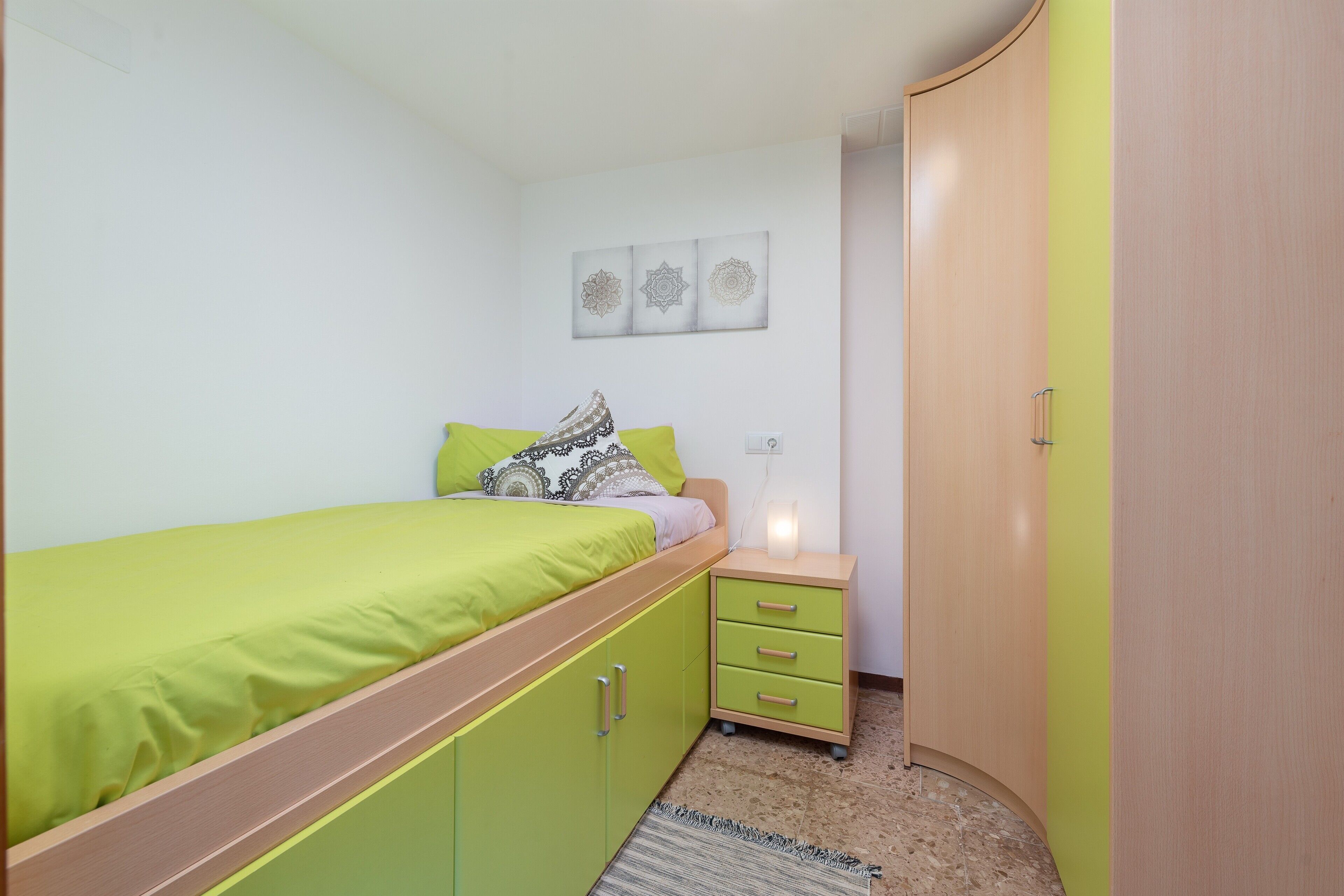 Une chambre à coucher comprenant un lit, une table de chevet, une armoire et une œuvre d’art accrochée au mur.