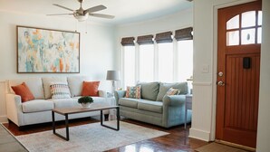 A living room with two sofas, a coffee table, and a painting on the wall.