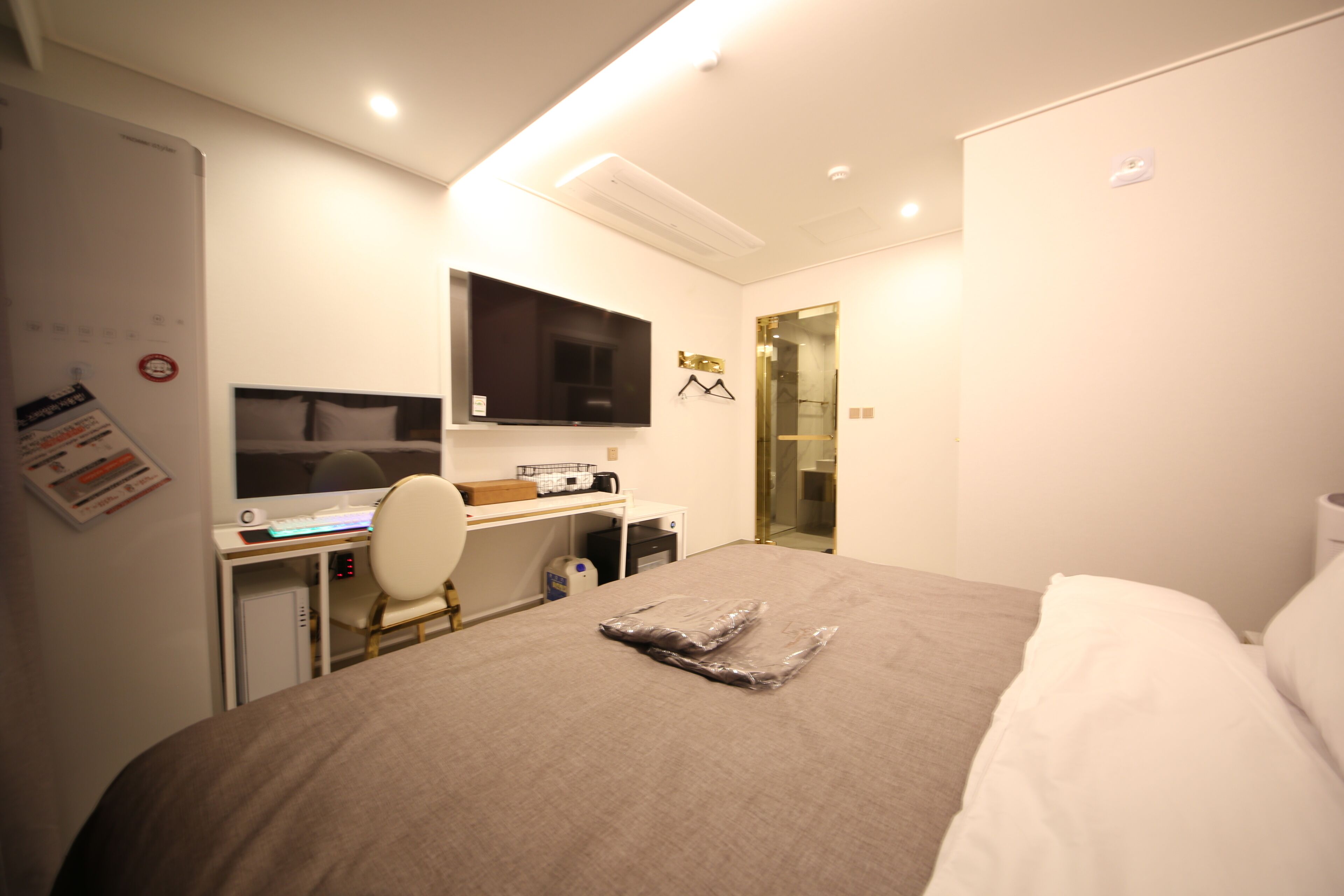 Une chambre d’hôtel équipée d’un lit, d’un bureau, d’une chaise et d’un téléviseur à écran plat.