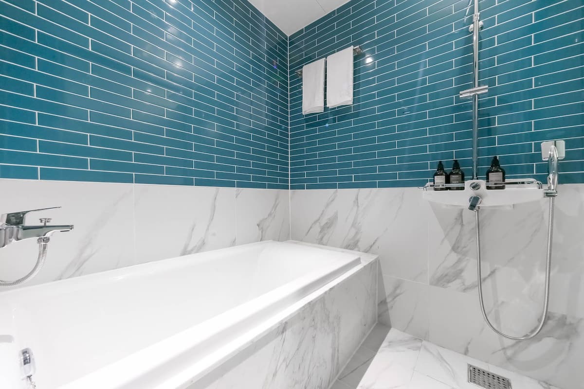 deluxe room | bathroom | shower, free toiletries, hair dryer, slippers