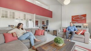 A modern living room with two sofas, a coffee table, and a dining area in the background. - Razorback 15 - Central Jindabyne CBD Unit (Jindabyne)
