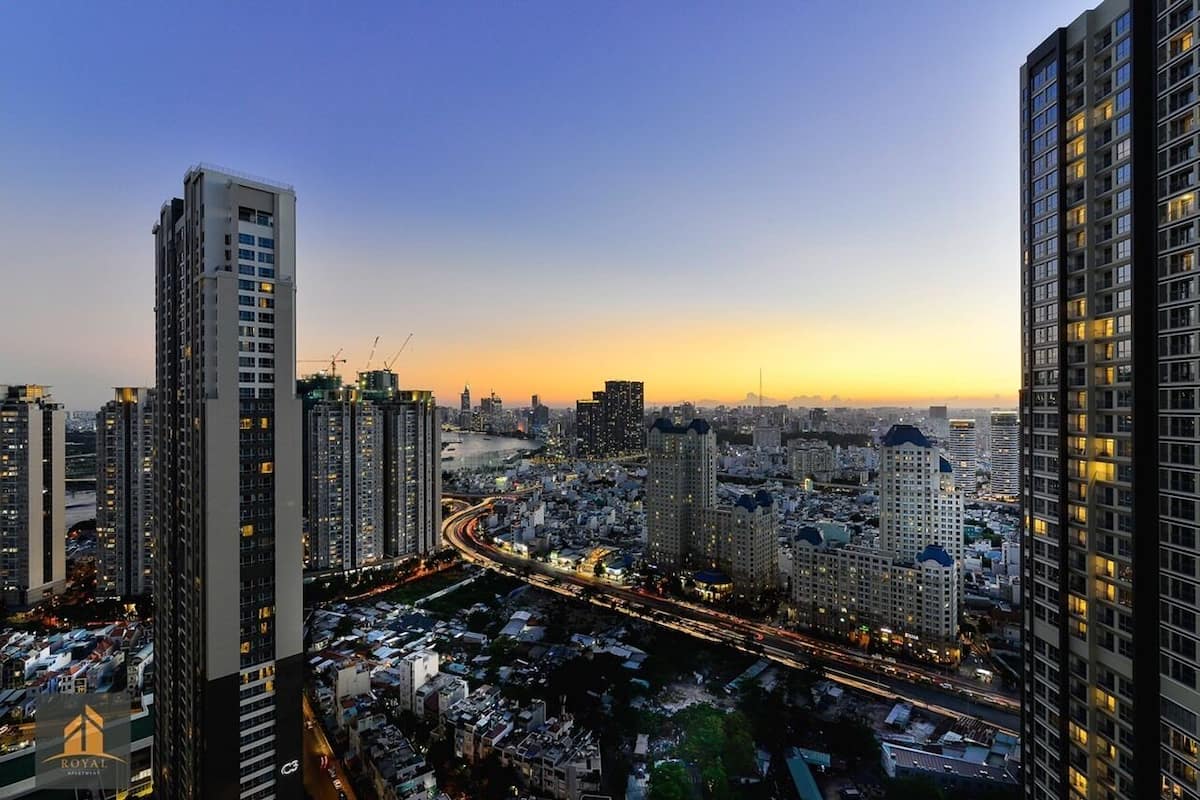 Un paisaje urbano con rascacielos, una autopista con mucho tráfico y un cielo al atardecer.
