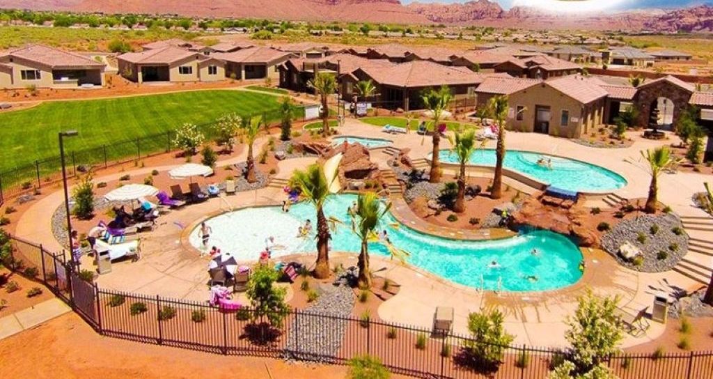 A resort with multiple swimming pools, lounge areas, and a mountainous backdrop.